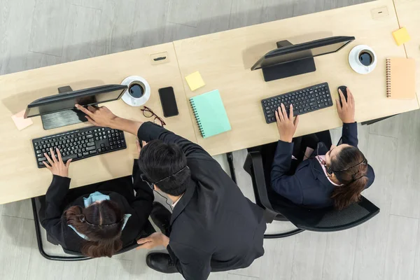 Деловые люди в наушниках с видом сверху в офисе, работающие с компьютером — стоковое фото