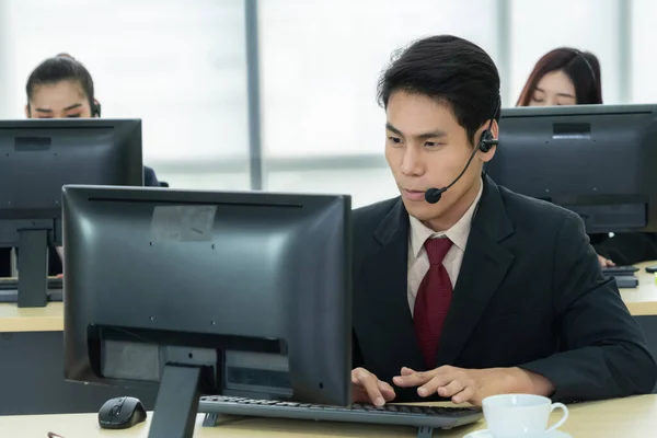 Zakenmensen met een koptelefoon aan het werk — Stockfoto