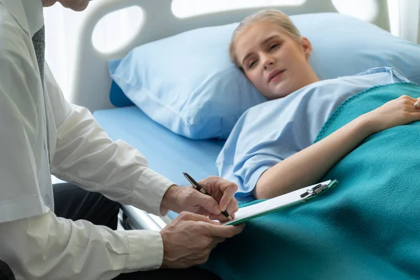 Doutor em uniforme profissional examinando paciente no hospital — Fotografia de Stock