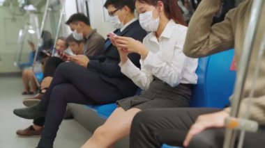 Kalabalık bir metroda maske takan insanlar.