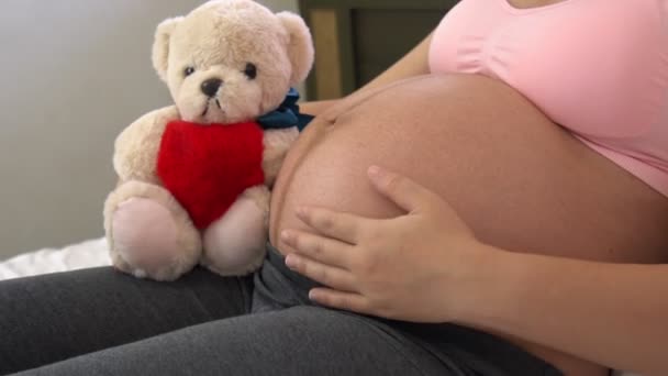 Onnellinen raskaana oleva nainen ja odottaa vauvaa kotona. — kuvapankkivideo