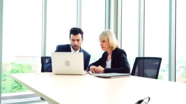 İki iş adamı ofiste proje stratejisi hakkında konuşuyor