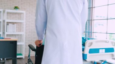 Profesyonel üniformalı doktor hastanedeki hastayı muayene ediyor.