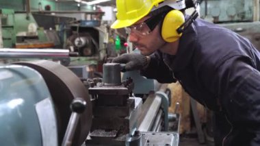 Fabrika atölyesinde makine kullanan akıllı bir fabrika işçisi