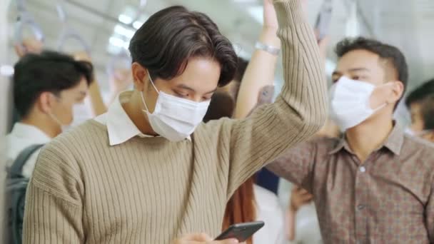 Viajante usando máscara facial ao usar o telefone celular no trem público — Vídeo de Stock
