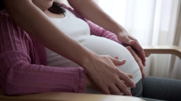 Couple enceinte se sent l'amour et se détendre à la maison. — Video