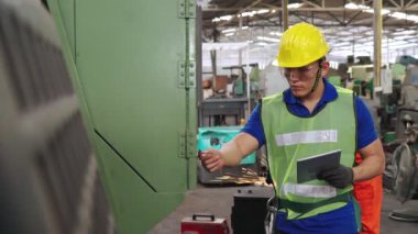 Fabrika atölyesinde makine kullanan akıllı bir fabrika işçisi