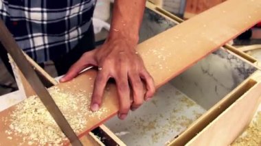 Marangoz atölyede ahşap işçiliği yapıyor.