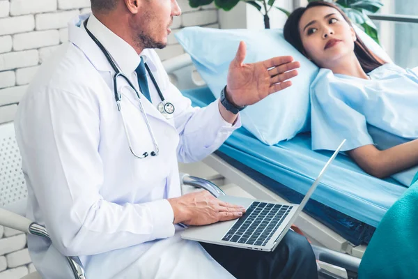 Doutor em uniforme profissional examinando paciente no hospital — Fotografia de Stock