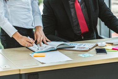 İki iş adamı ofiste proje stratejisi hakkında konuşuyor