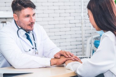 Profesyonel üniformalı doktor hastanedeki hastayı muayene ediyor.