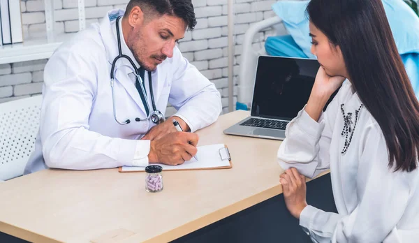 Doutor em uniforme profissional examinando paciente no hospital — Fotografia de Stock