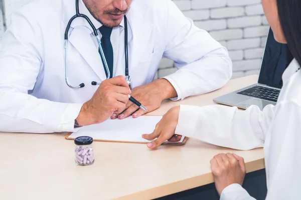 Médico en uniforme profesional examinando al paciente en el hospital — Foto de Stock