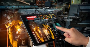 Mühendis, artırılmış gerçeklik endüstrisi teknolojisiyle robotik kolları kontrol ediyor.