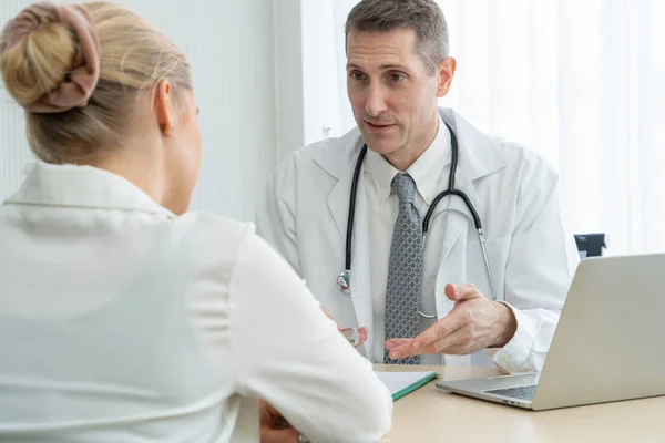 Doctor in professioneel uniform die de patiënt in het ziekenhuis onderzoekt — Stockfoto