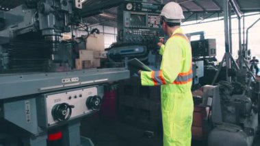 Fabrika atölyesinde makine kullanan akıllı bir fabrika işçisi