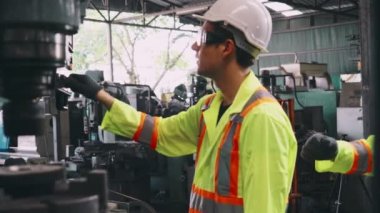 Fabrika atölyesinde makine ekipmanı kullanan bir grup işçi.