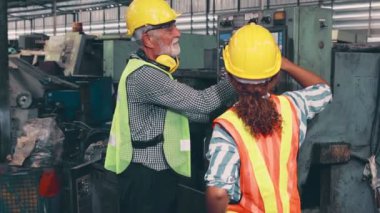 Fabrika atölyesinde makine ekipmanı kullanan bir grup işçi.