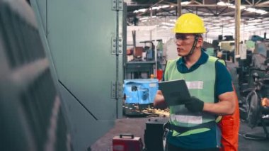 Fabrika atölyesinde makine kullanan akıllı bir fabrika işçisi