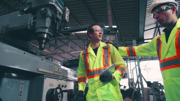 Trabalhador da fábrica avisar o colega de trabalho sobre a segurança e dar hardhat para ele — Vídeo de Stock