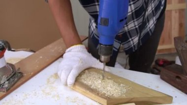 Marangoz atölyede ahşap işçiliği yapıyor.