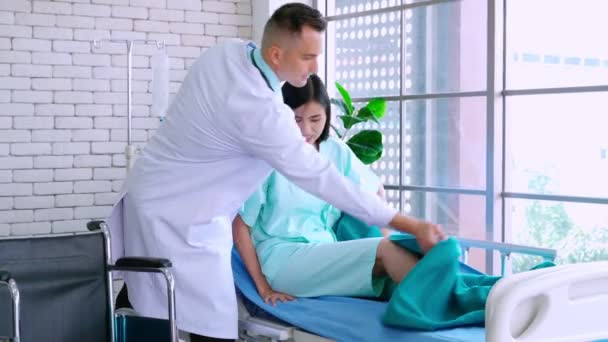 Врач в профессиональной форме осматривает пациента в больнице — стоковое видео