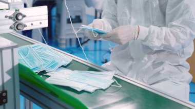 Modern fabrikada yüz maskesi üretim hattı