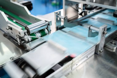 Modern fabrikada yüz maskesi üretim hattı