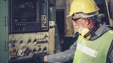 Fabrika atölyesinde makine kullanan akıllı bir fabrika işçisi