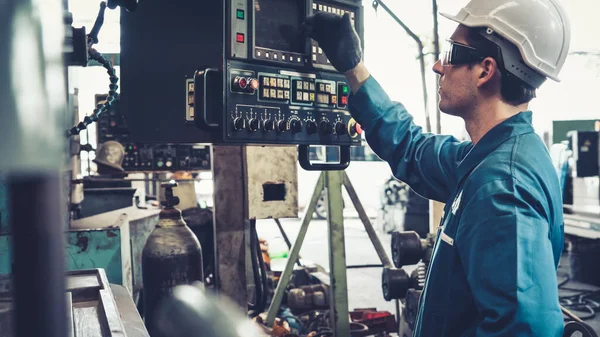 Fabrika atölyesinde makine kullanan akıllı bir fabrika işçisi — Stok fotoğraf