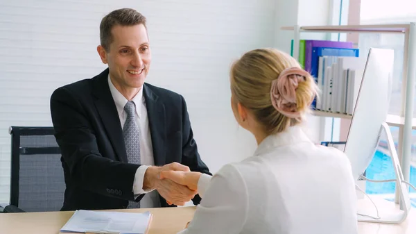 Job seeker and manager handshake in job interview