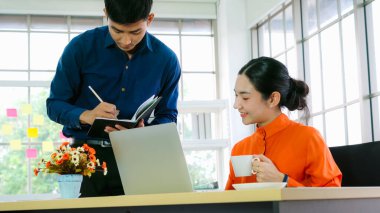 İki iş adamı ofiste proje stratejisi hakkında konuşuyor