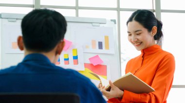 Genç kadın iş verilerini beyaz tahtada açıklıyor