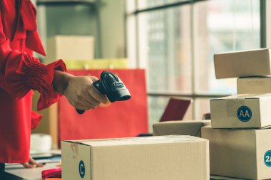 Çevrimiçi satıcı ev ofisinde çalışıyor ve teslimat kutusunu müşteriye paketliyor. İnternette e-ticaret yapan küçük işletme sahibi ya da girişimci.