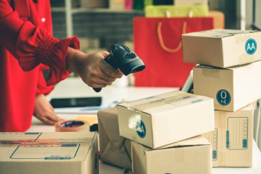 Çevrimiçi satıcı ev ofisinde çalışıyor ve teslimat kutusunu müşteriye paketliyor..