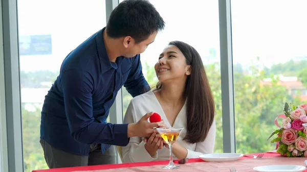 Romantic couple giving gift to lover at restaurant — Stock Photo, Image