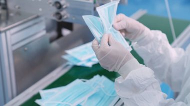 Modern fabrikada yüz maskesi üretim hattı. Covid-19 Coronavirus 2019 üretimi kavramı .