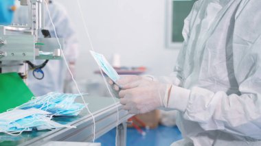 Modern fabrikada yüz maskesi üretim hattı. Covid-19 Coronavirus 2019 üretimi kavramı .