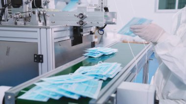 Modern fabrikada yüz maskesi üretim hattı