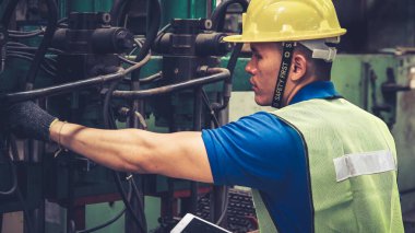Fabrika atölyesinde makine kullanan akıllı bir fabrika işçisi