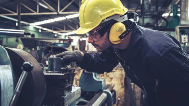 Fabrika atölyesinde makine kullanan akıllı bir fabrika işçisi