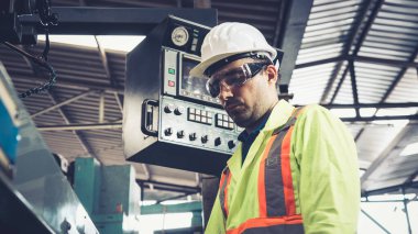 Fabrika atölyesinde makine kullanan akıllı bir fabrika işçisi