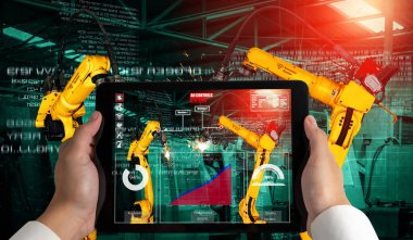 Mühendis, artırılmış gerçeklik endüstrisi teknolojisiyle robotik kolları kontrol ediyor.