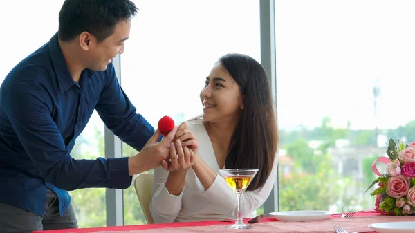 Romantic couple giving gift to lover at restaurant — Stock Photo, Image