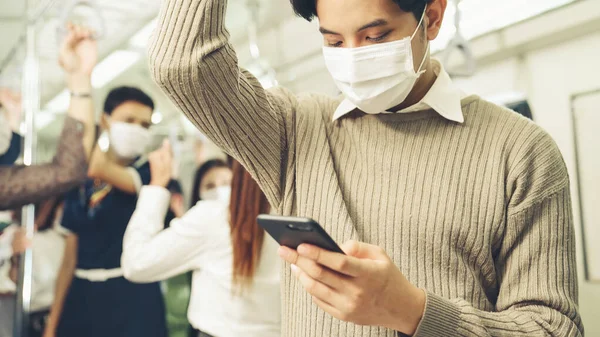 Reisender trägt Gesichtsmaske bei Handynutzung in S-Bahn — Stockfoto