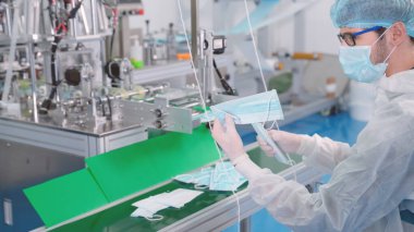 Modern fabrikada yüz maskesi üretim hattı