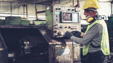 Fabrika atölyesinde makine kullanan akıllı bir fabrika işçisi