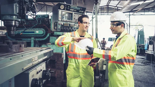 Factory worker warn coworker about safety and give hardhat to him