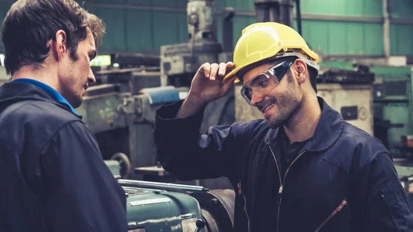 Tired factory workers taking a break and talking to coworker in the factory