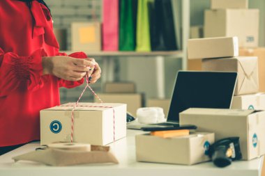 Çevrimiçi satıcı ev ofisinde çalışıyor ve teslimat kutusunu müşteriye paketliyor..